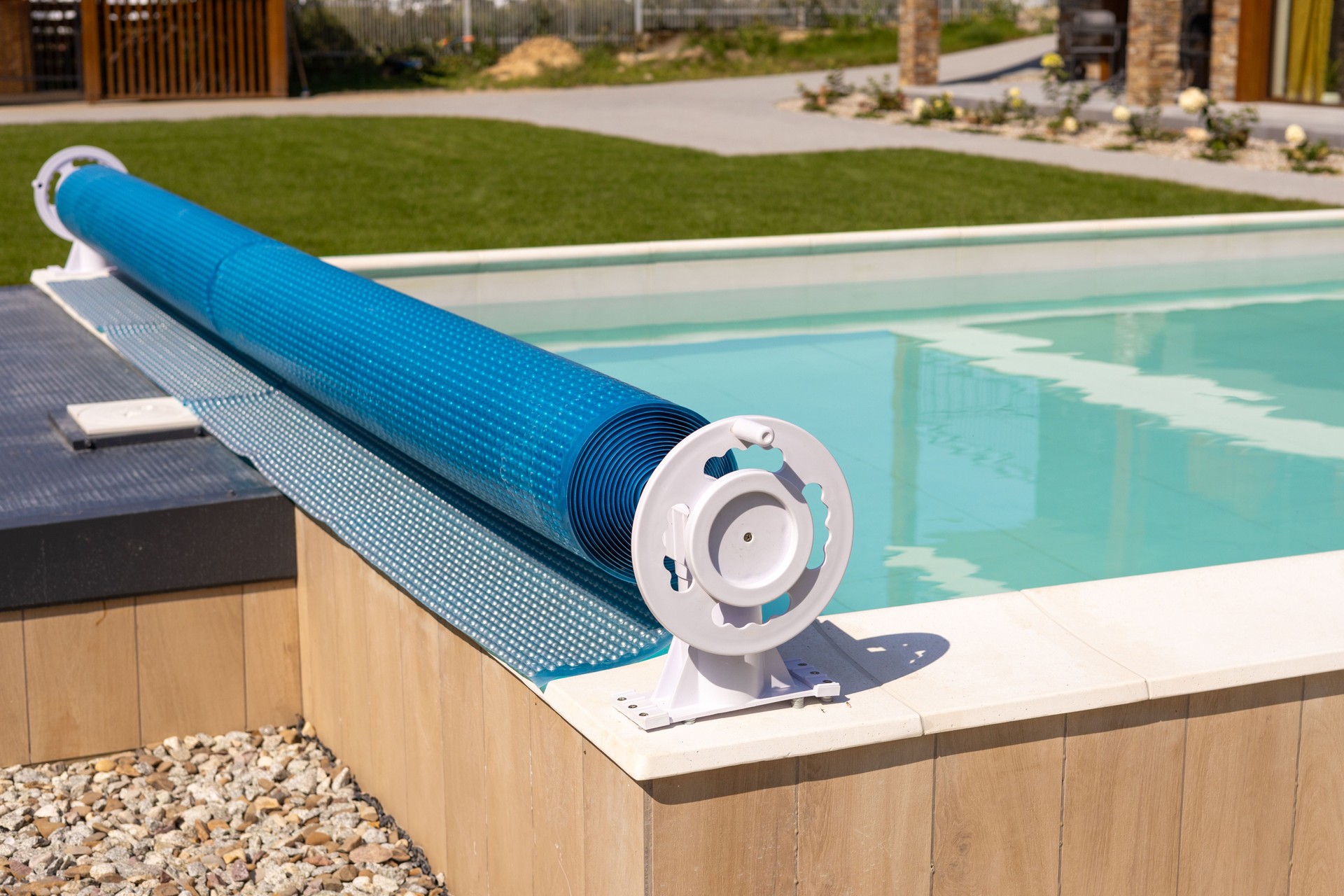 Swimming pool cover for protection against dirt, leaves, heating and cooling water, copy space. Blue tarpaulin pool cover. Summer day